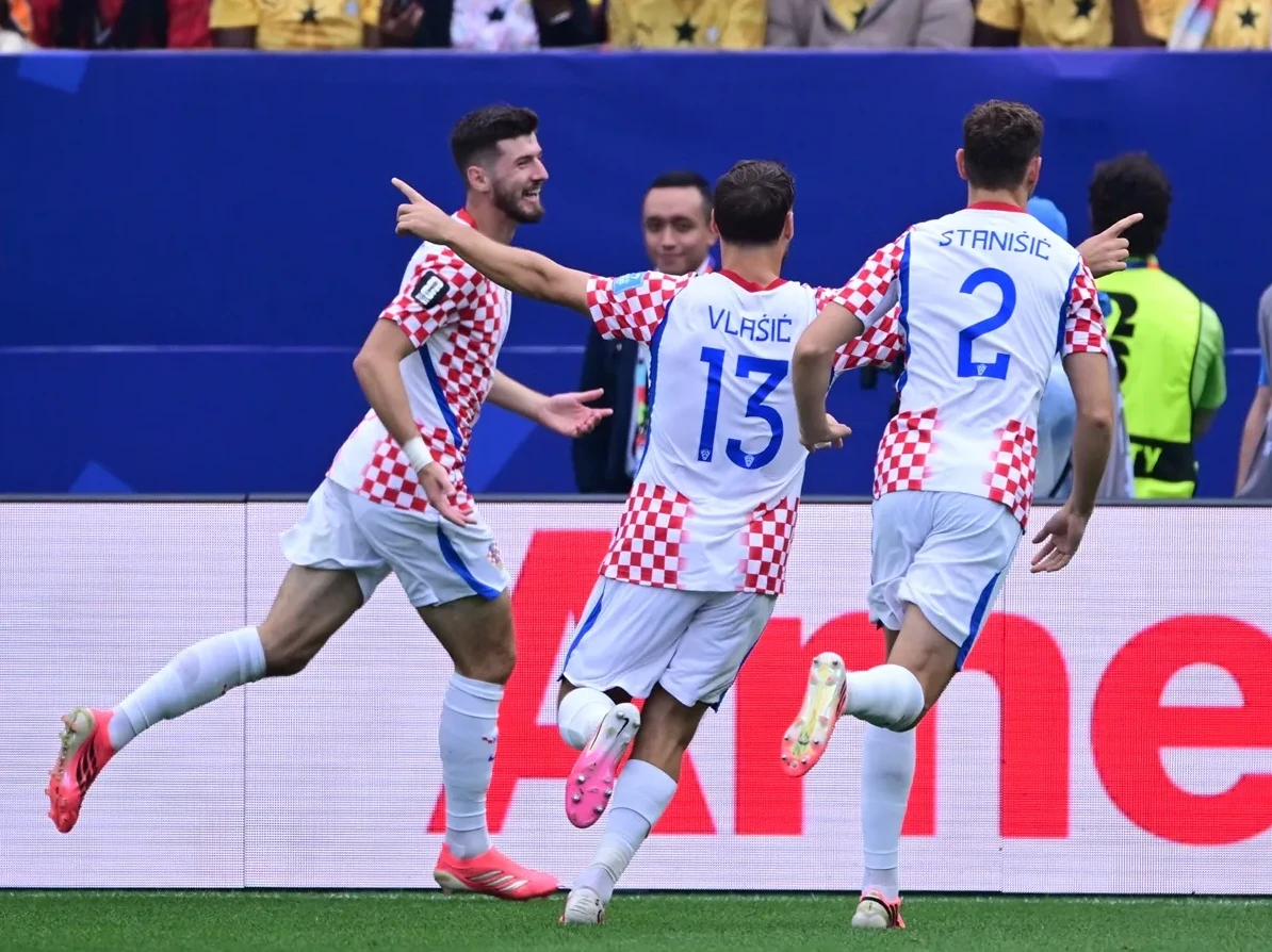 Hrvatski fudbaleri u bijelim dresovima sa crveno-bijelim kvadratićima slave postignuti gol na terenu.