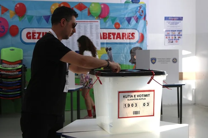 Čovjek ubacuje glasački listić u glasačku kutiju.