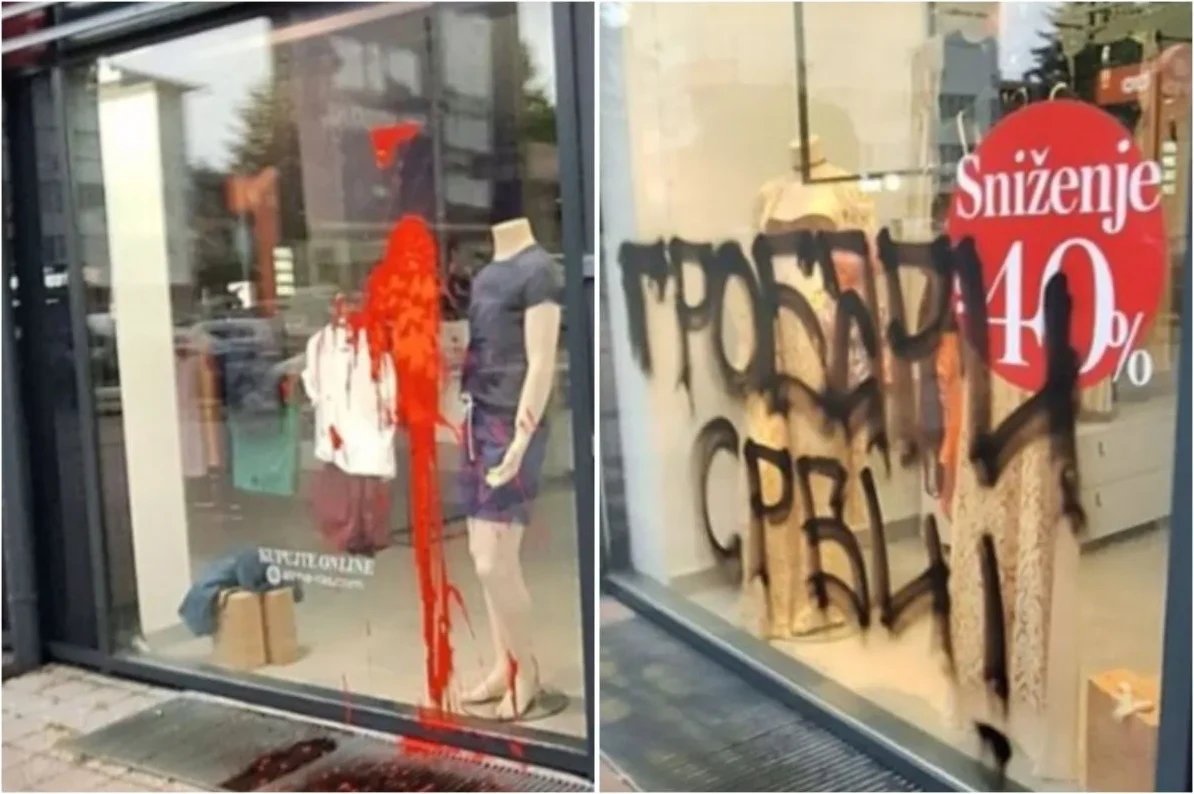Izlog radnje vandalizovan crvenom bojom i grafitima, sa natpisom "Sniženje 40%" u pozadini.