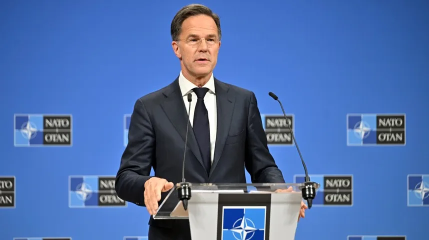 Mark Rutte drži govor pred NATO logom.