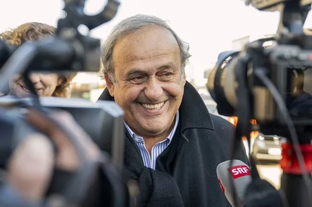 Mišel Platini smiješi se novinarima ispred kamera