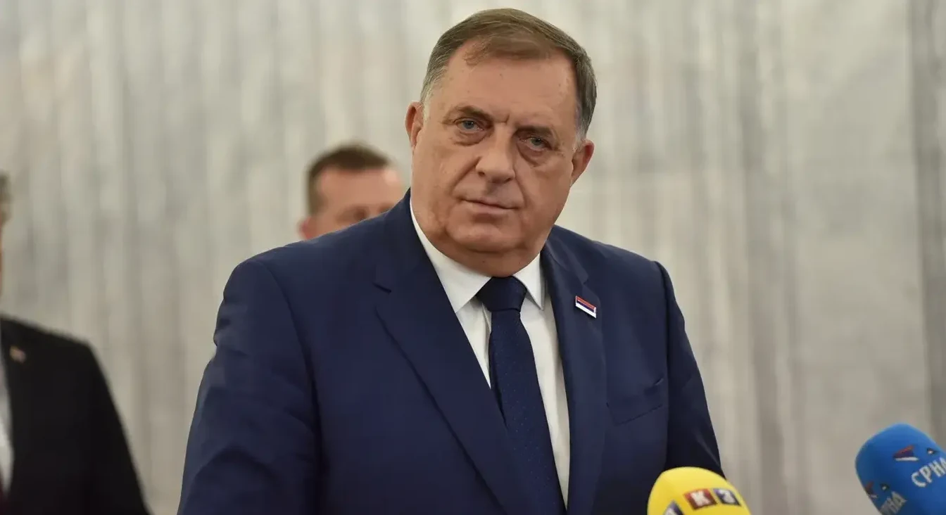 Milorad Dodik, političar iz Republike Srpske, obučen u tamnoplavo odijelo i kravatu, stoji pred novinarima sa nekoliko mikrofona ispred sebe.