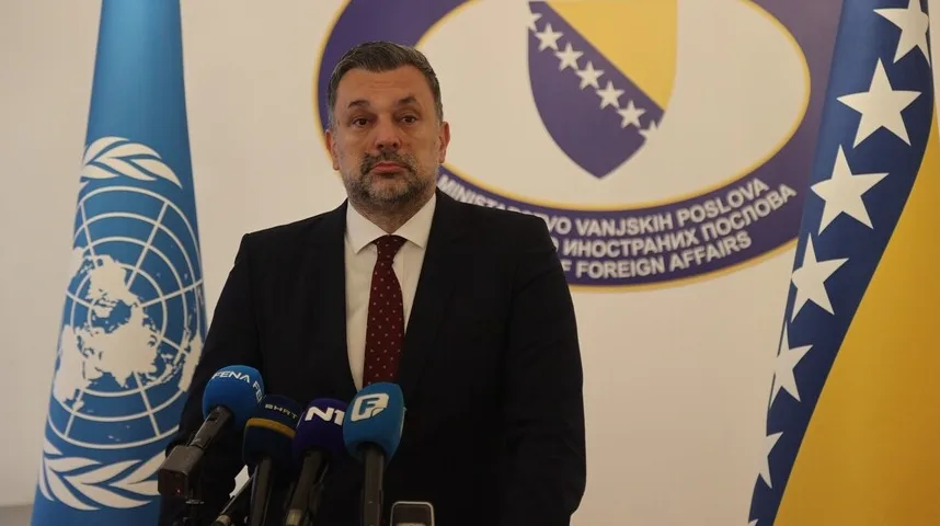 Muškarac u tamnom odijelu sa crvenom kravatom stoji ispred mikrofona sa logom Ministarstva vanjskih poslova Bosne i Hercegovine, zastavom BiH i zastavom Ujedinjenih Nacija.