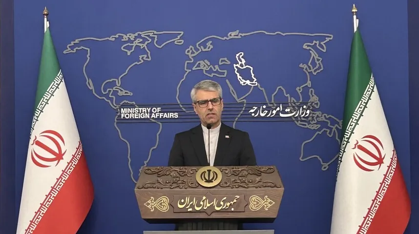 Ministar vanjskih poslova Irana drži govor iza govornice, s iranskim zastavama sa obje strane.