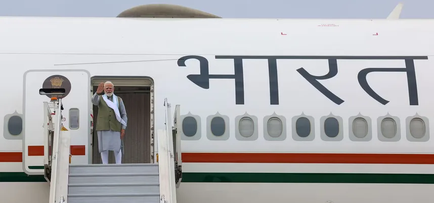 Narendra Modi maše dok silazi stepenicama iz aviona s natpisom 'Bharat'