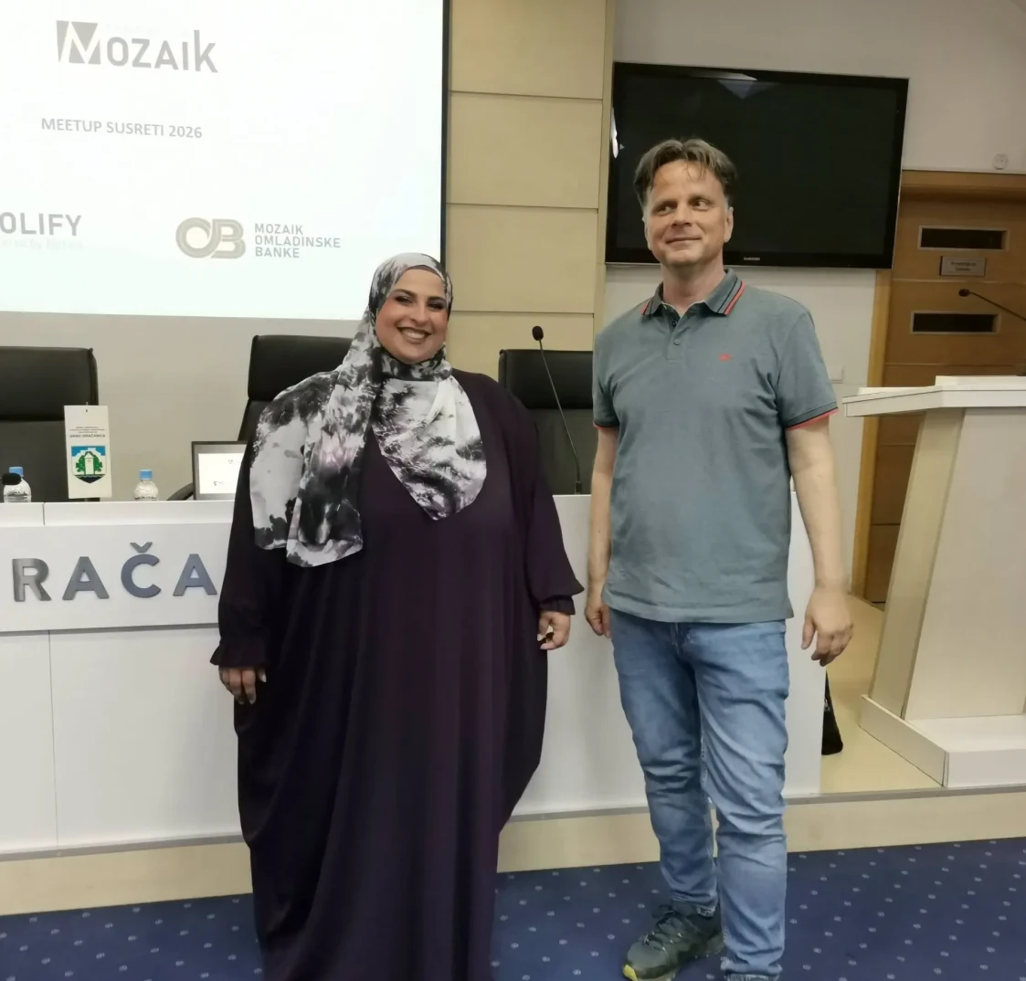 Dva učesnika, žena u hidžabu i muškarac u majici, stoje ispred bine na Mozaik Meetup Susretima 2026.