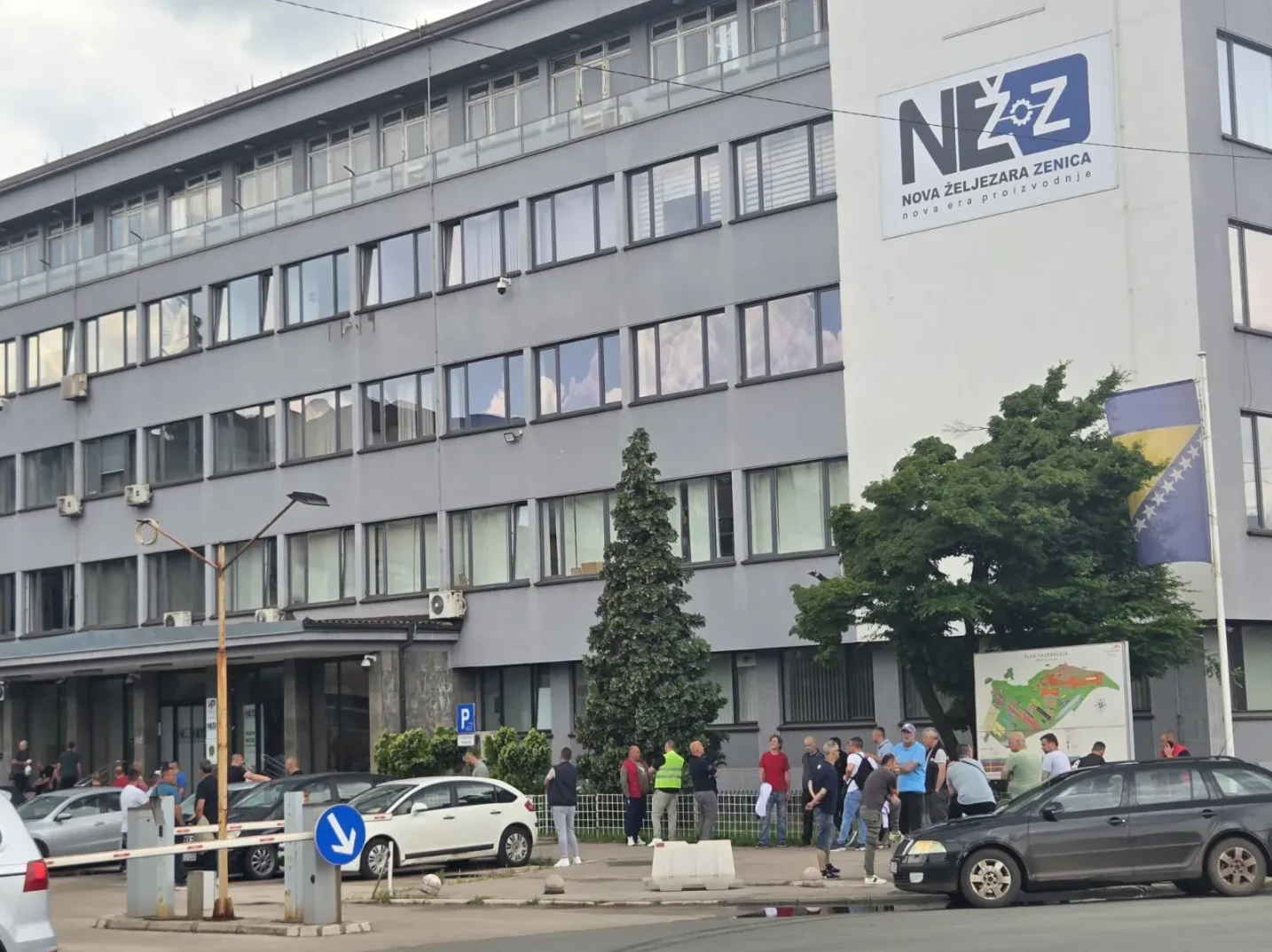 Zgrada "Nove željezare Zenica" sa logom kompanije i zastavom Bosne i Hercegovine.