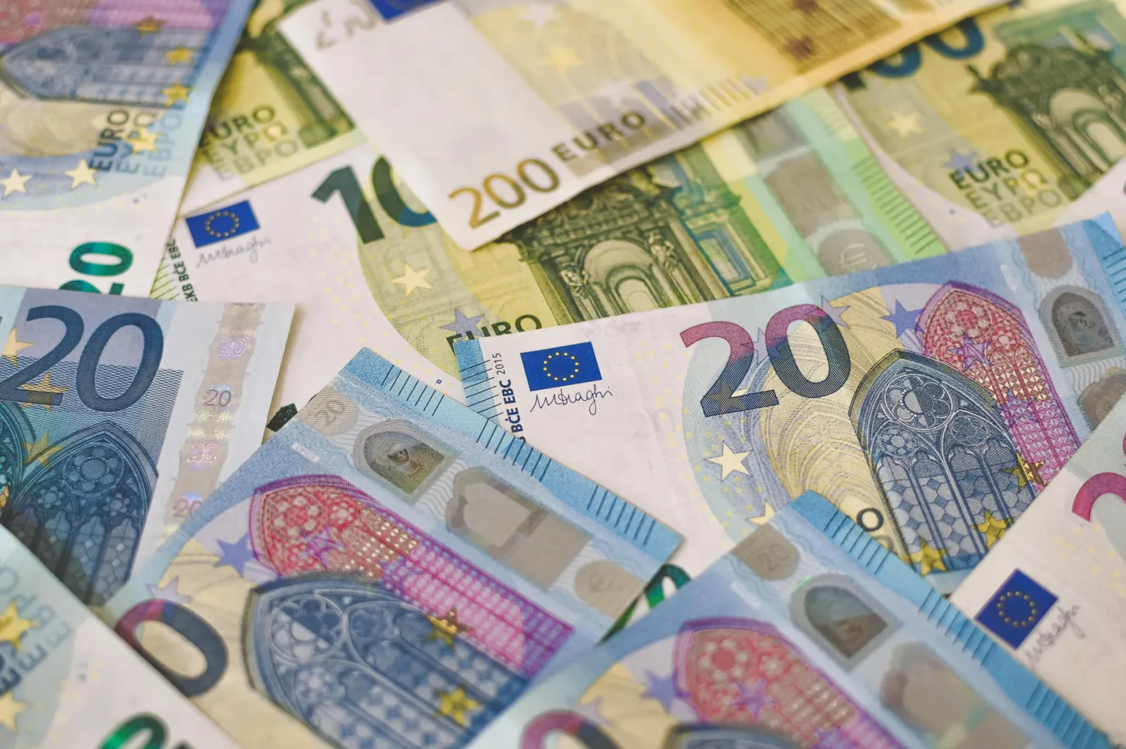 Gomila novčanica eura u raznim apoenima, uključujući 20, 100 i 200 eura.