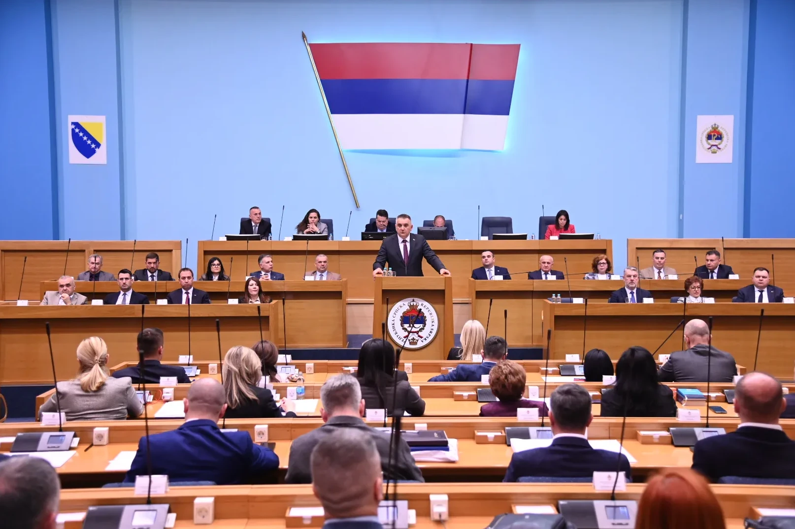 Čovjek govori sa govornice u parlamentu dok sjede poslanici.