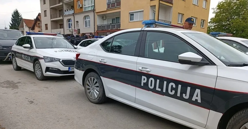 Bijeli policijski automobili sa natpisom "POLICIJA" parkirani u ulici.