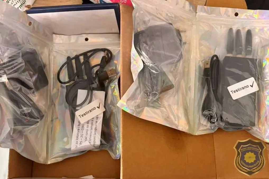 Fotografija prikazuje policijsku zapljenu raznih elektronskih uređaja upakovanih u plastične vrećice, uključujući džamere signala i punjače.