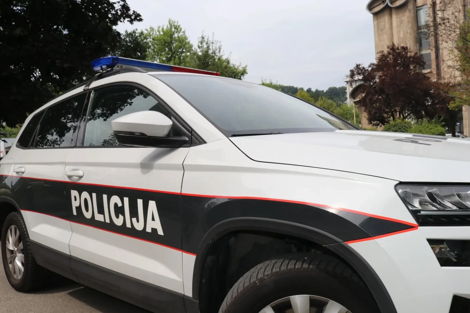 Bijeli policijski automobil s natpisom "POLICIJA"