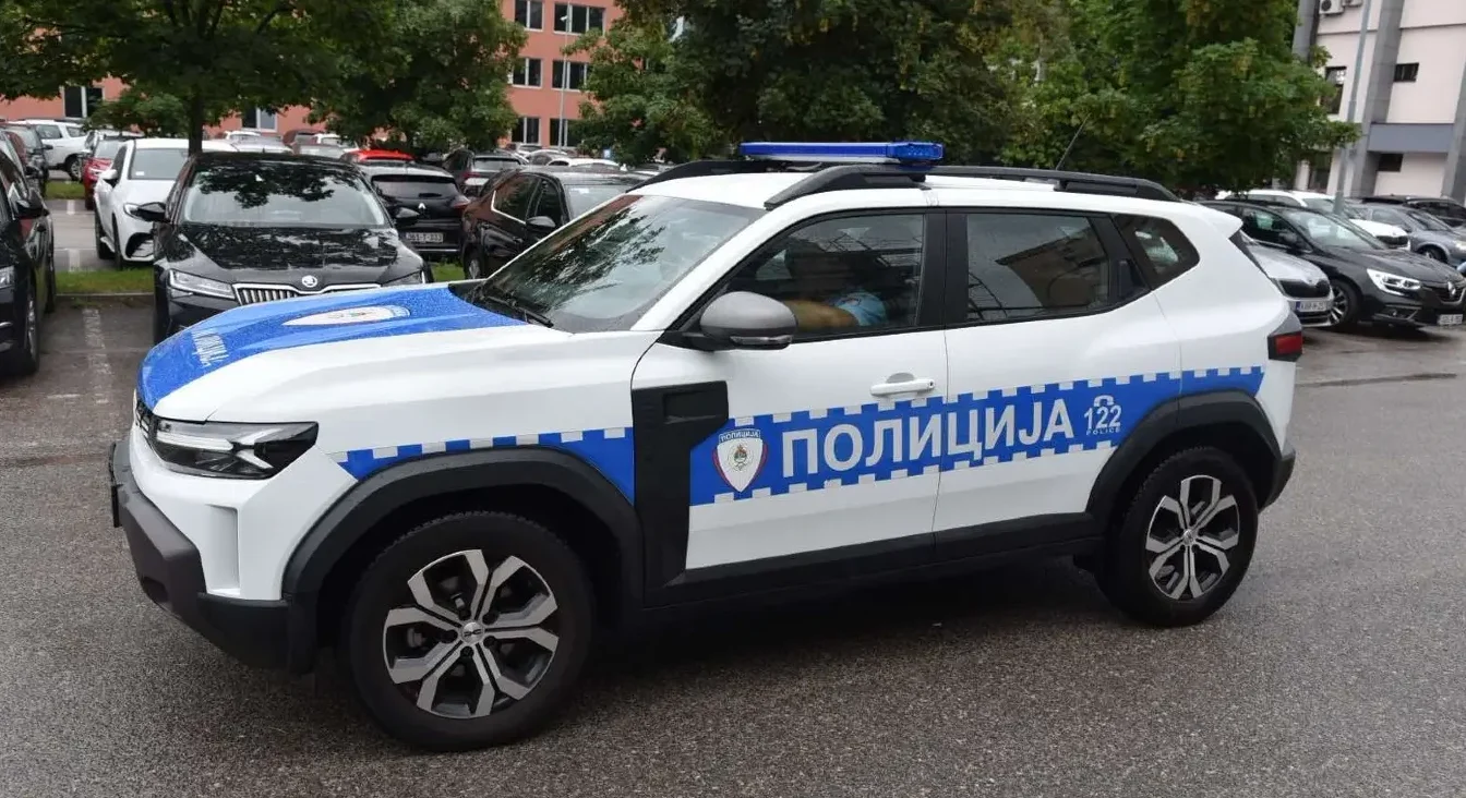 Policijsko vozilo marke Dacia, bijele boje sa plavom trakom i natpisom "POLICIJA 122".