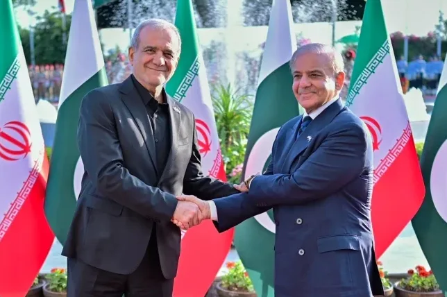 Dvojica političara, premijer Pakistana Shehbaz Sharif i iranski ministar vanjskih poslova Hossein Amirabdollahian, rukuju se ispred zastava Pakistana i Irana.
