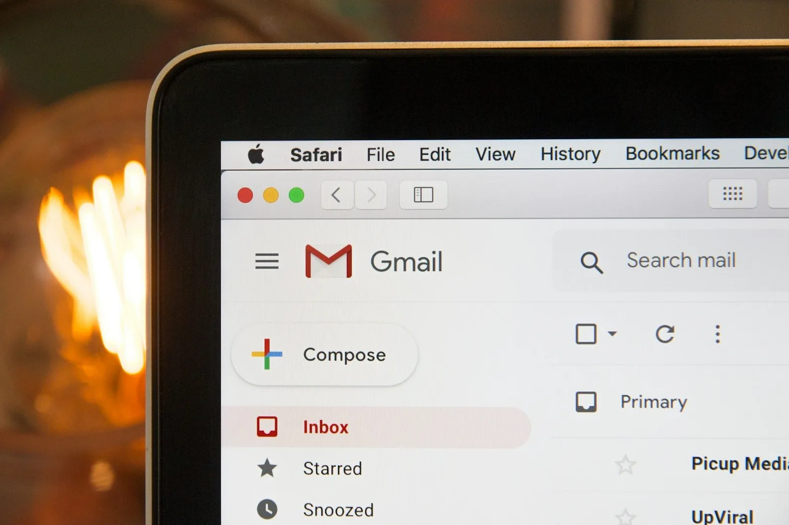 Detaljan prikaz Gmail sučelja na ekranu laptopa, prikazujući meni sa opcijama 'Inbox', 'Starred' i 'Snoozed', te dugme za 'Compose'.