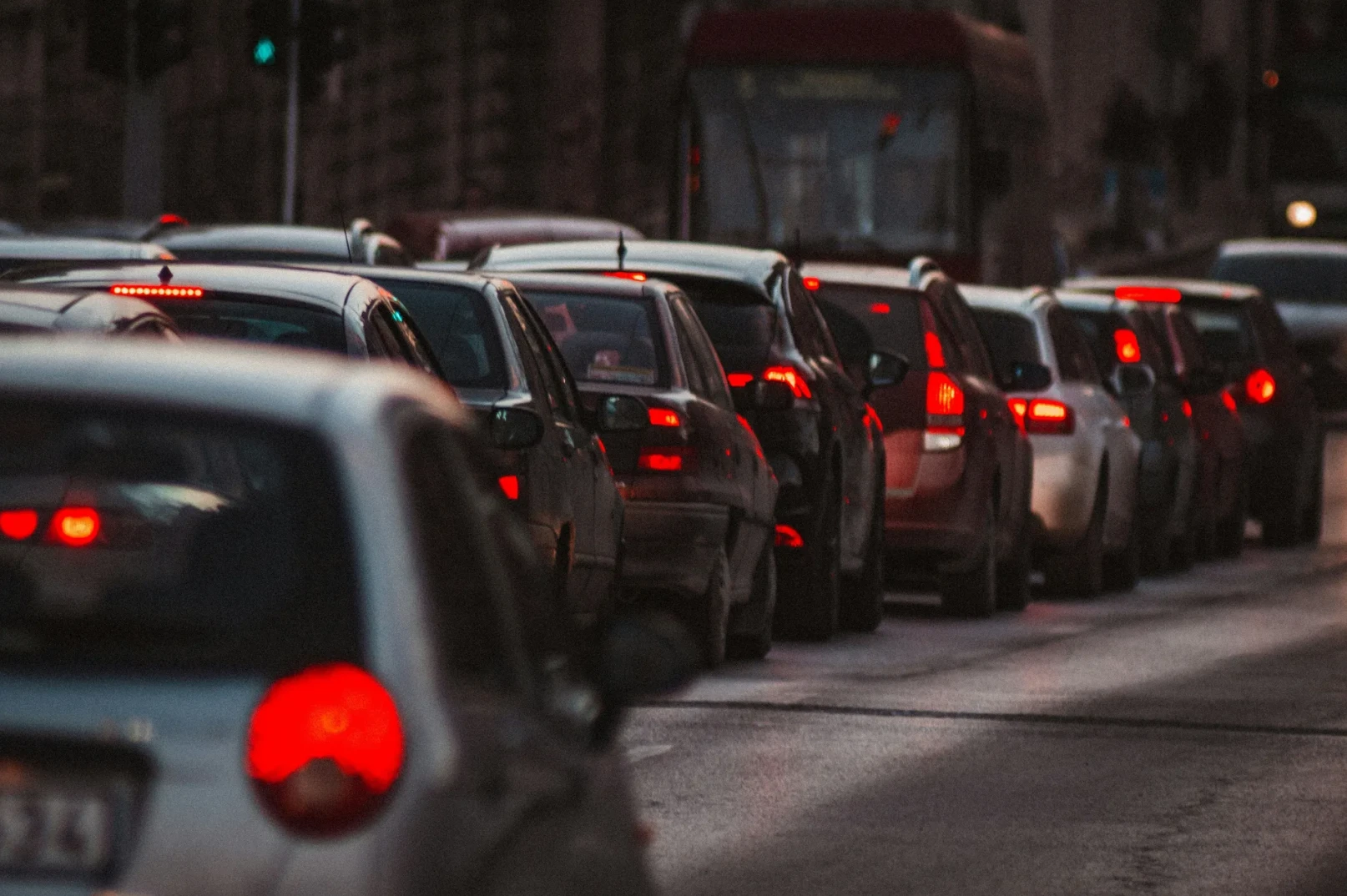 Kolona automobila u saobraćajnoj gužvi, sa upaljenim kočionim svjetlima.