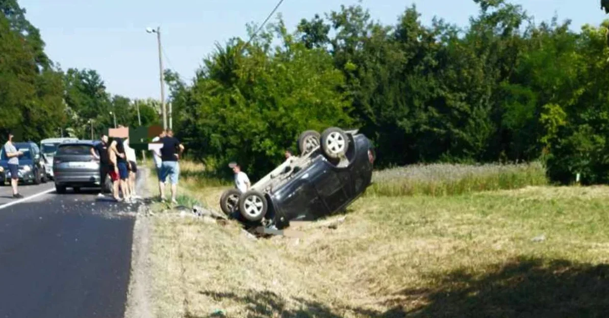Saobraćajna nesreća sa prevrnutim automobilom na cesti, okupilo se nekoliko osoba.