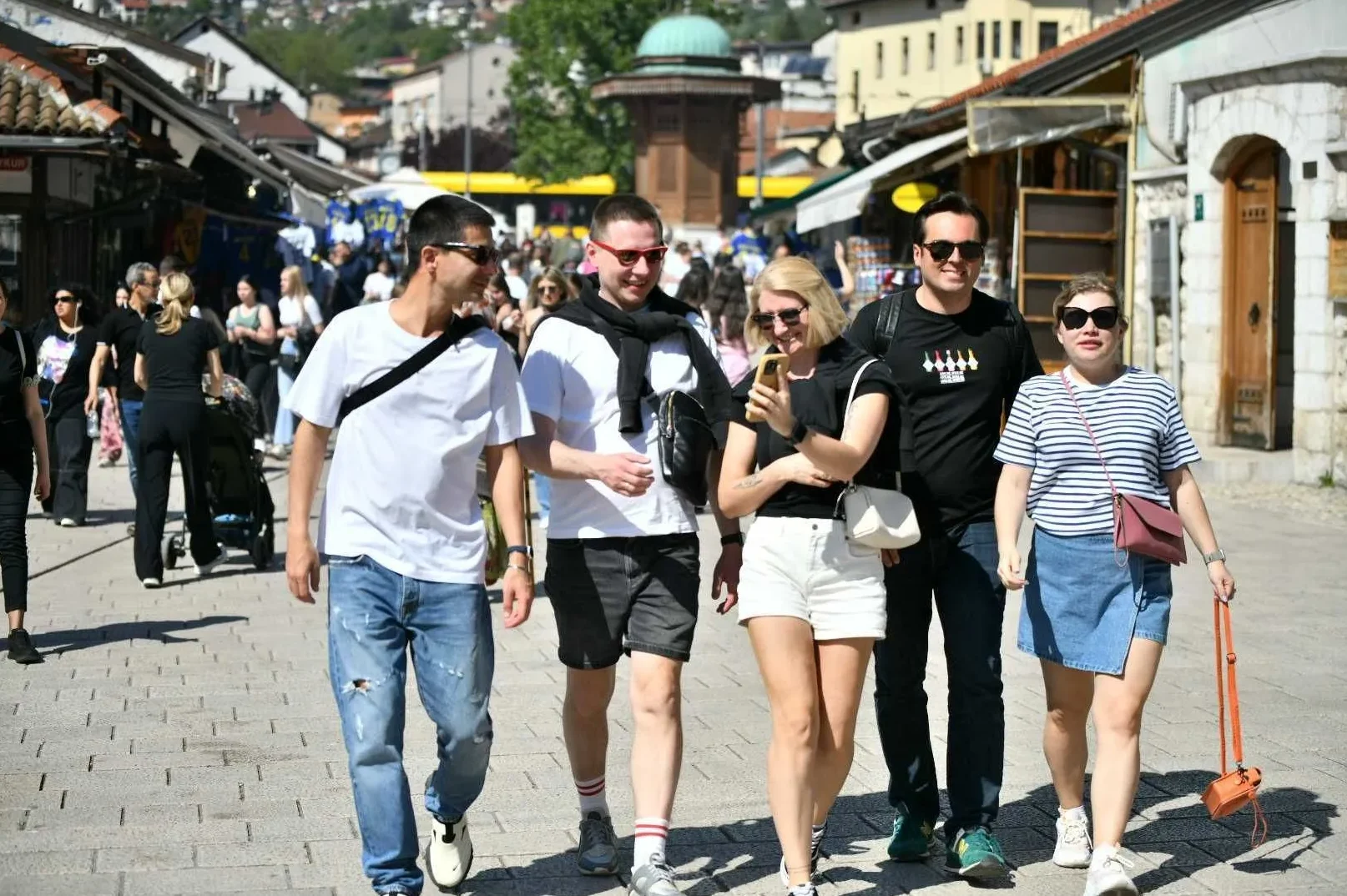 Grupa turista, dva muškarca i dvije žene, šeta ulicom Baščaršije u Sarajevu.