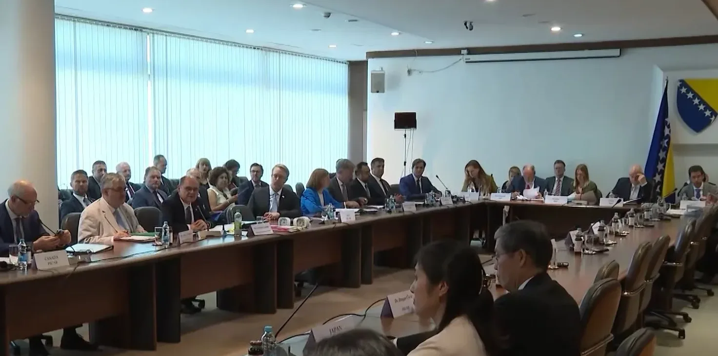 Učesnici sastanka sjede za dugim stolom, sa zastavama Bosne i Hercegovine i Evropske unije u pozadini.