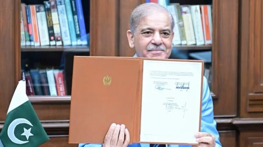 Pakistanski premijer Shehbaz Sharif drži dokument s potpisima.
