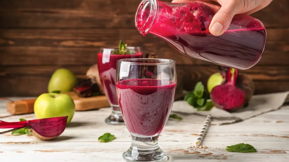 Sipanje svježeg soka od cvekle i jabuka u čašu