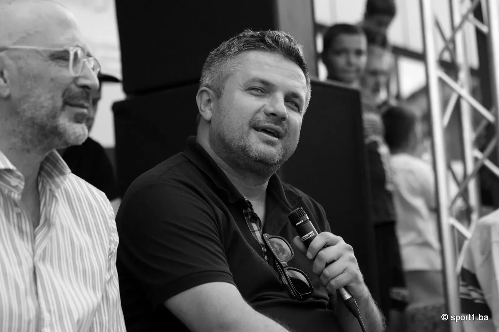 Čovjek drži mikrofon i razgovara
