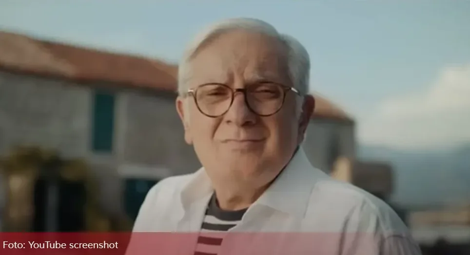 Portret starijeg gospodina sa sijedom kosom i naočalama, odjevenog u bijelu košulju preko prugaste majice.