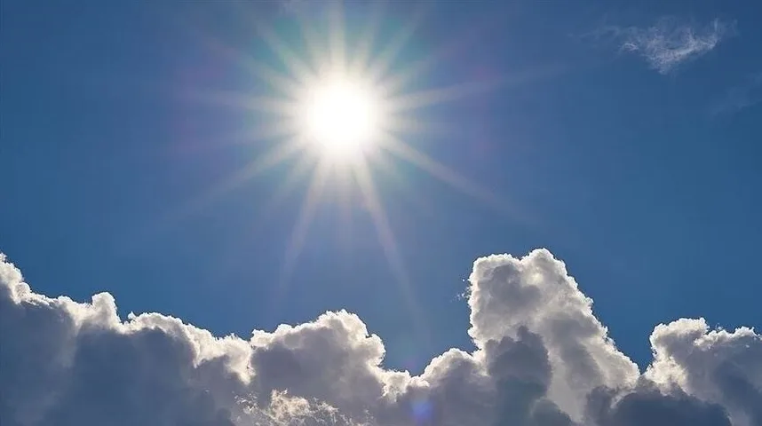 Sunce koje sija jarko na plavom nebu sa bijelim oblacima.