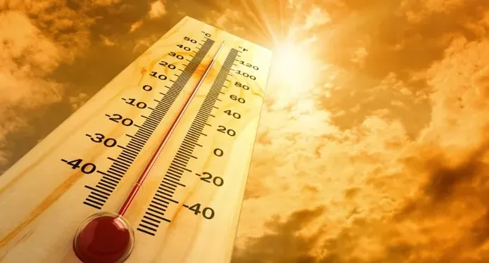Termometar koji pokazuje visoku temperaturu uz jarko sunce i narandžaste oblake