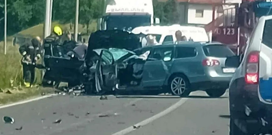 Teška saobraćajna nesreća na putu, oštećena vozila i prisutne ekipe hitne pomoći i vatrogasaca.