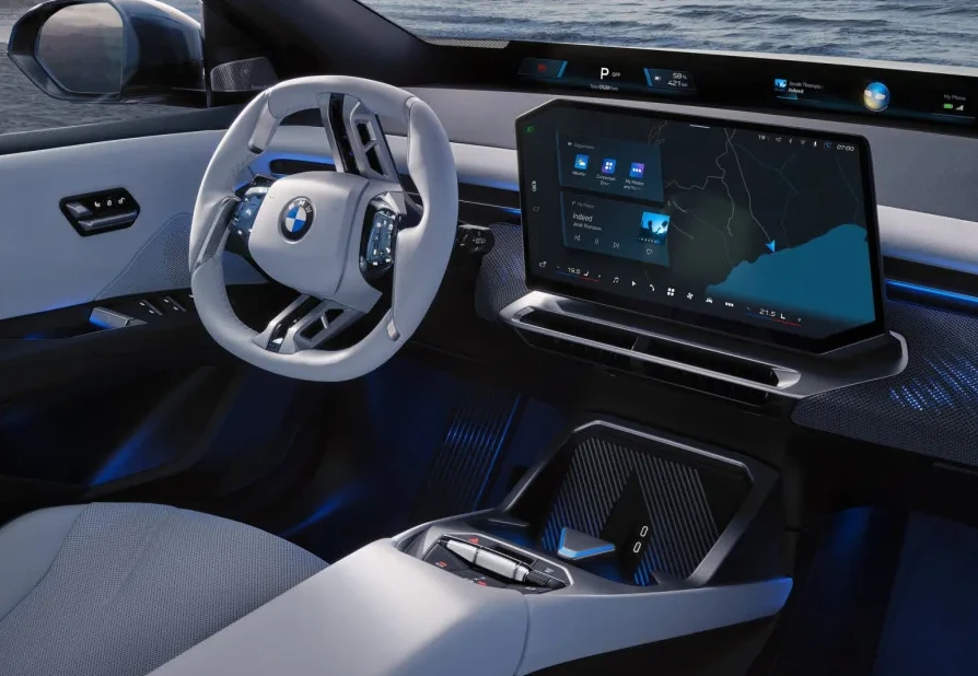 Pogled na unutrašnjost modernog BMW-a sa velikim zakrivljenim ekranom, digitalnim volanom i futurističkim dizajnom