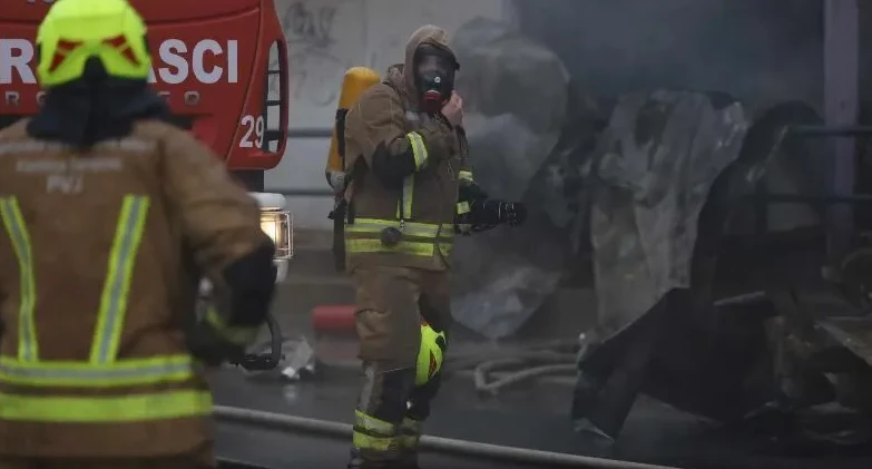 Vatrogasac sa maskom i opremom za disanje u akciji gašenja požara.