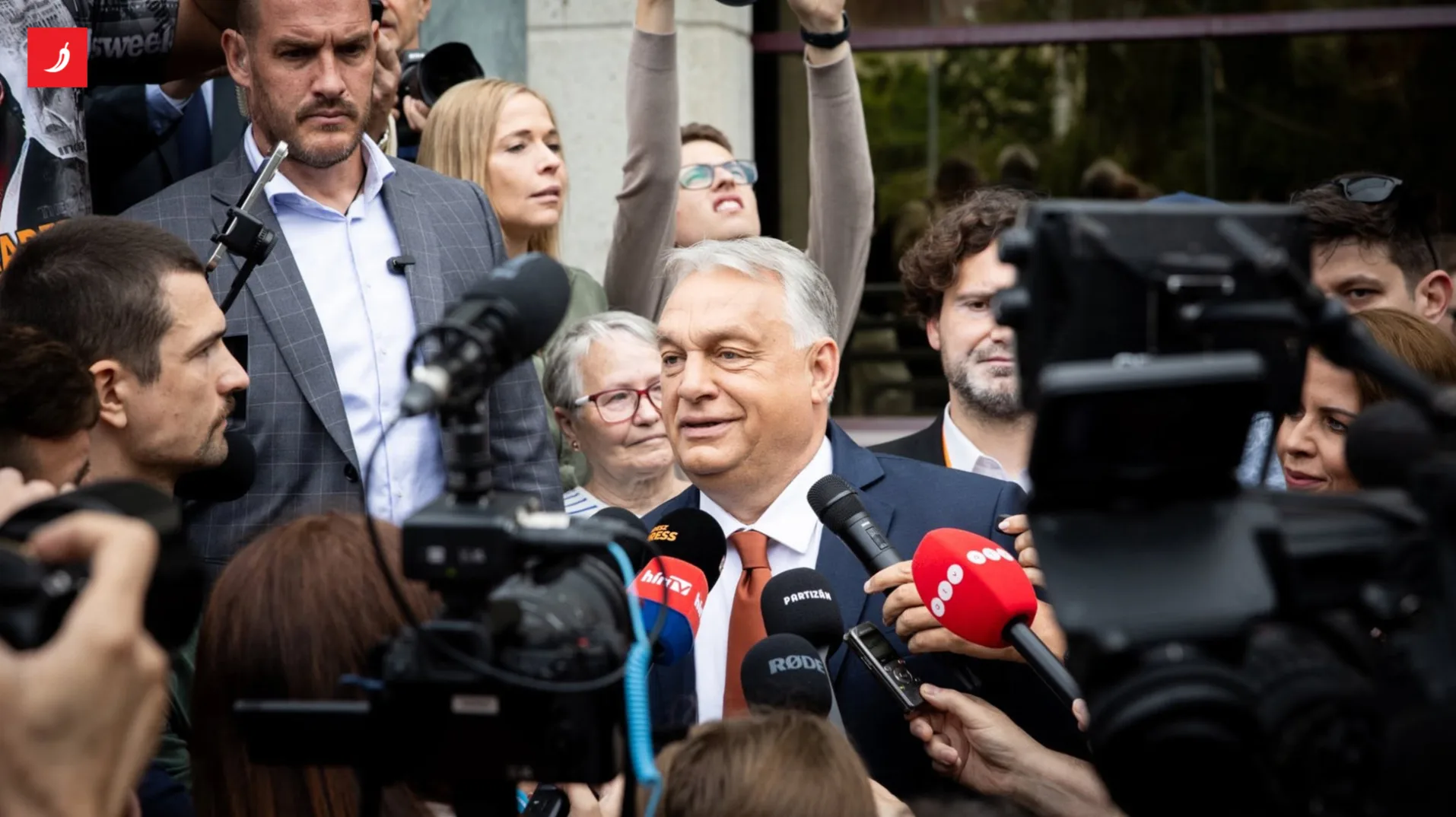 Viktor Orban okružen novinarima i kamerama daje izjavu medijima, u pozadini se vide okupljeni ljudi.