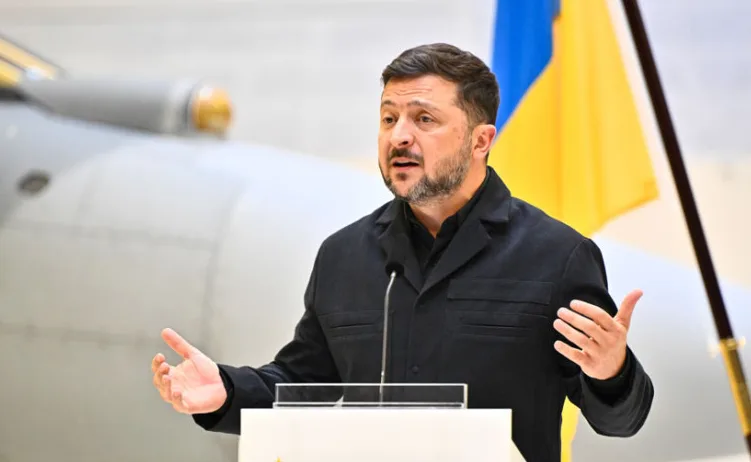 Ukrajinski predsjednik Volodimir Zelenski govori iza podijuma sa ukrajinskom zastavom u pozadini.