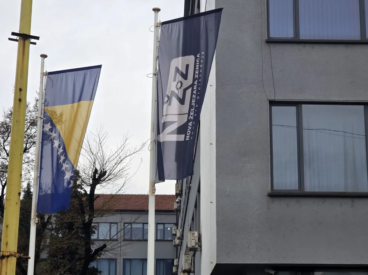 Zastava Bosne i Hercegovine pored zastave sa logom "Nova željezara Zenica"