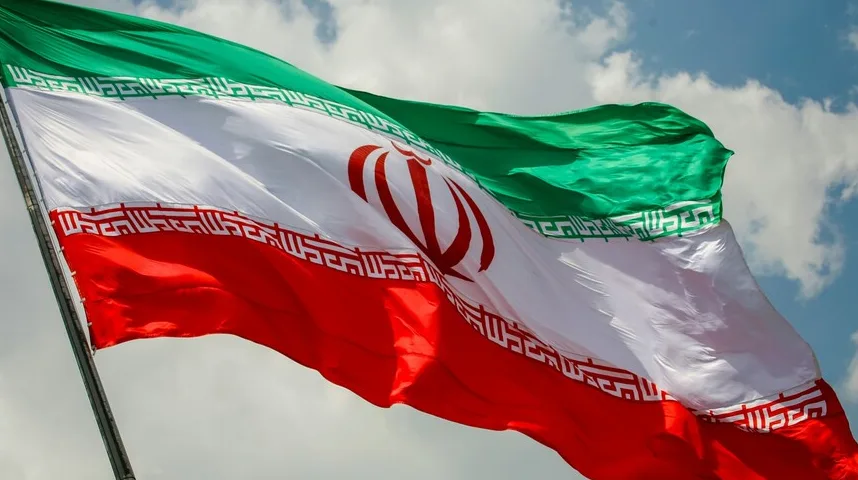 Zastava Islamske Republike Iran vijori na povjetarcu, prikazujući njene karakteristične boje zelenu, bijelu i crvenu, sa arapskim pismom i grbom u sredini.