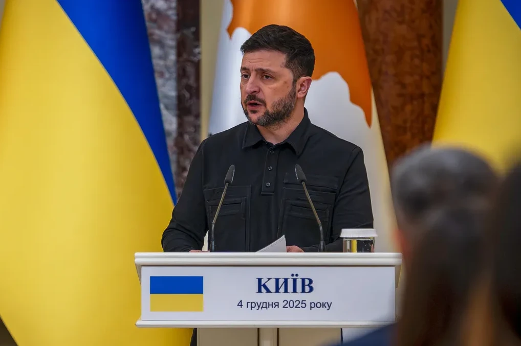 Volodimir Zelenski, ukrajinski predsjednik, govori za govornicom sa ukrajinskom zastavom u pozadini.