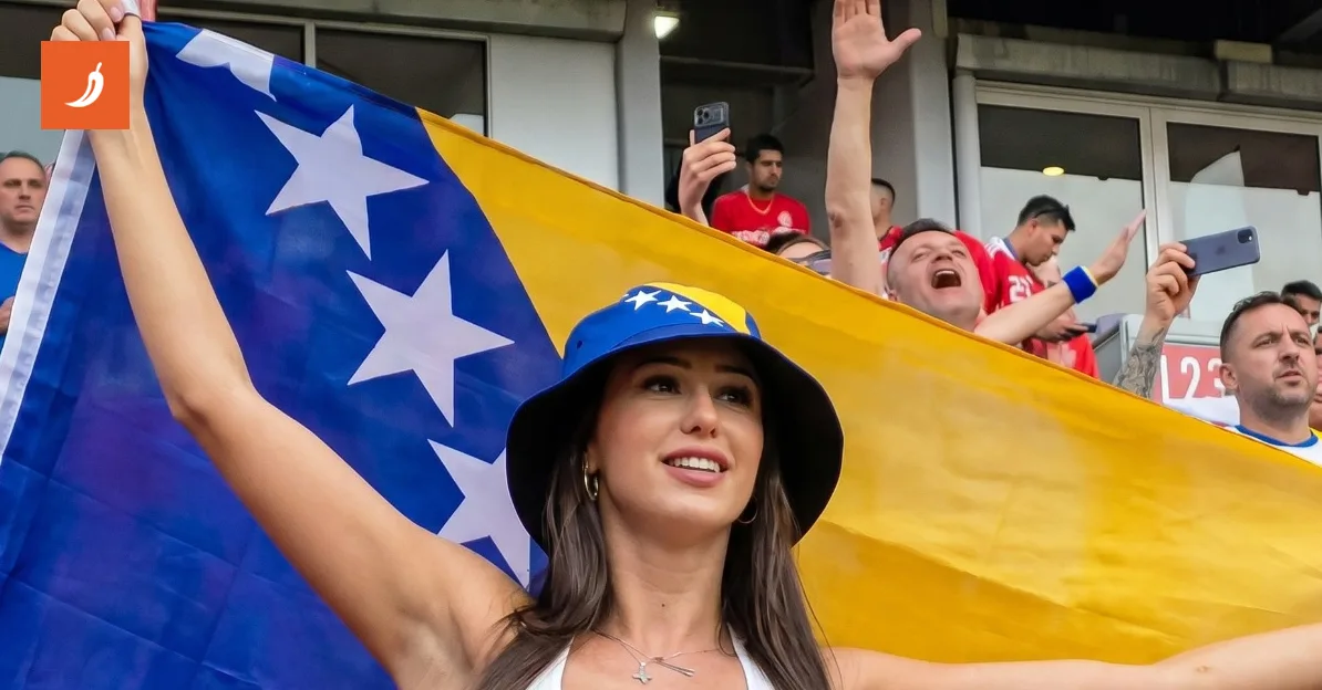 Žena nosi šešir sa motivom zastave Bosne i Hercegovine i drži zastavu BiH na stadionu.