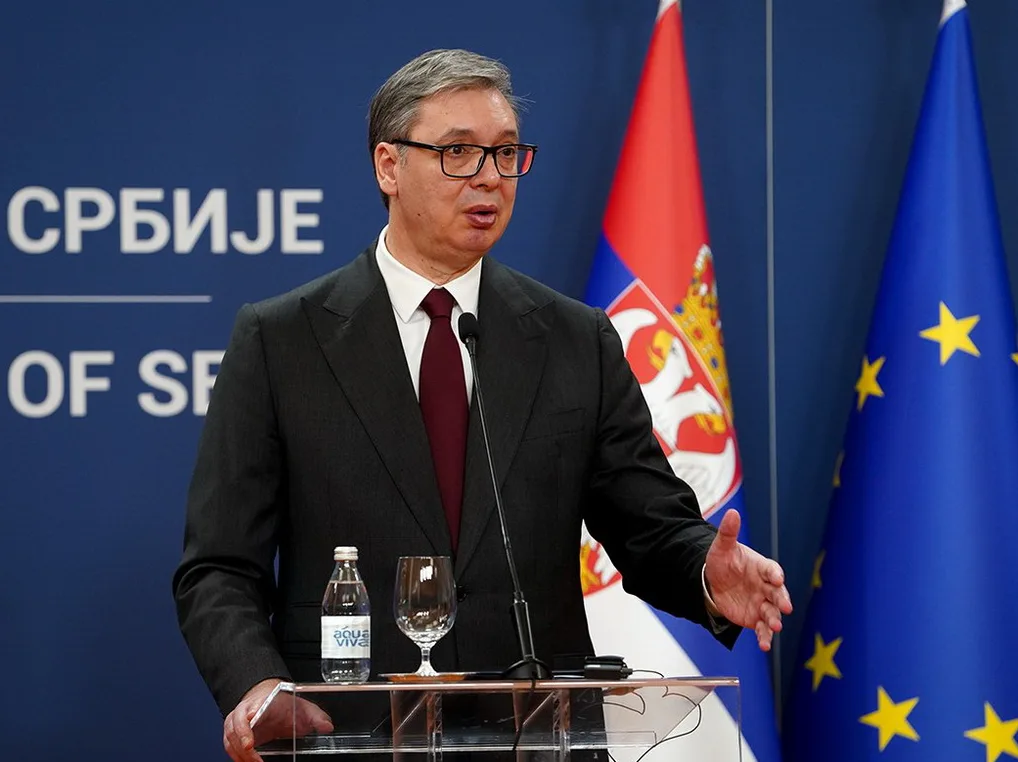 Aleksandar Vučić govori za govornicom ispred zastava Srbije i Evropske Unije.