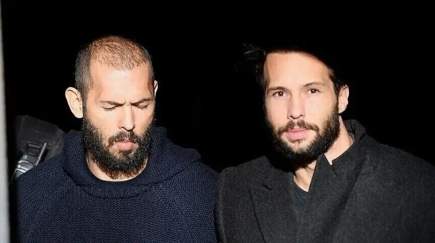 Andrew Tate i Tristan Tate sa gustim bradama, gledaju dole
