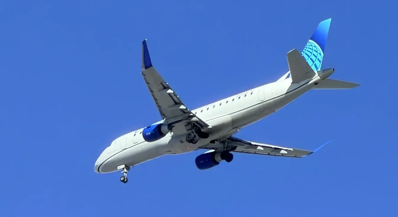 Avion United Airlines u letu na plavom nebu.
