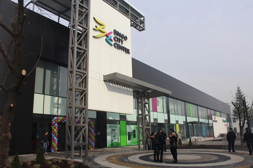 Moderna zgrada Bingo City Centra sa šarenim balonima ispred ulaza i ljudima koji stoje ispred.
