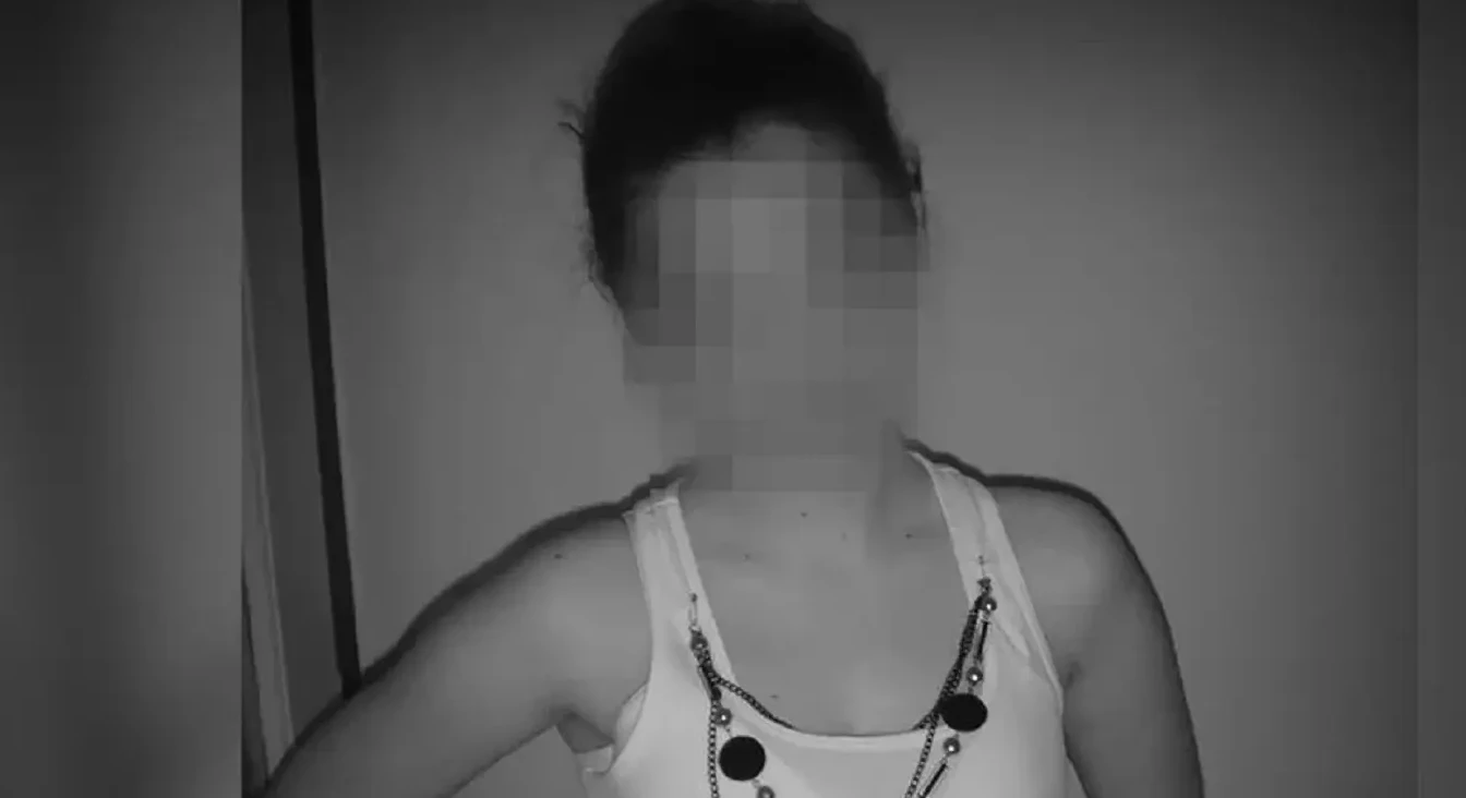 Crno-bijeli portret žene koja nosi bijelu majicu bez rukava i ukrasnu ogrlicu.