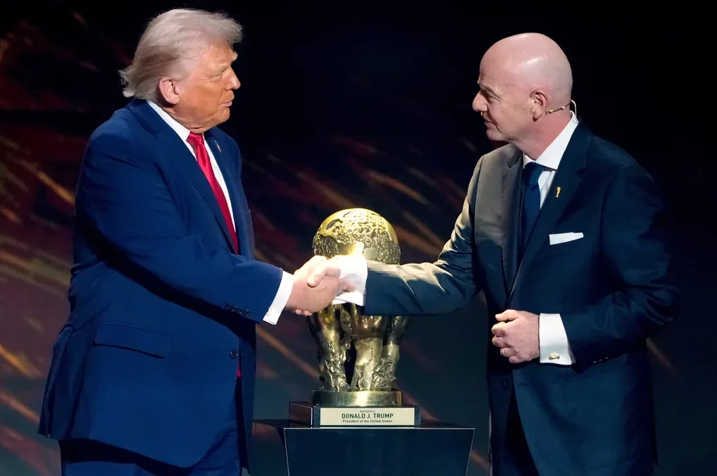 Donald Tramp i Đijani Infantino se rukuju pored zlatnog trofeja.