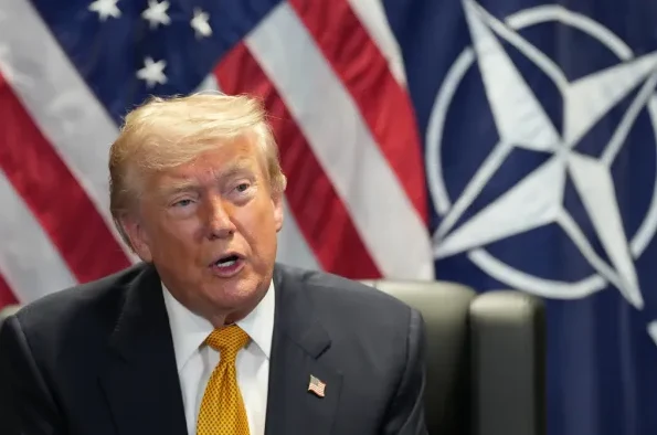 Donald Trump sa američkom i NATO zastavom u pozadini