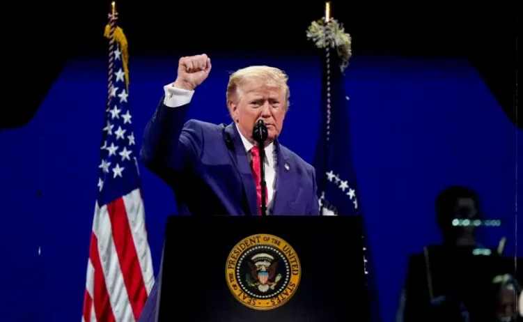 Donald Trump podignute pesnice iza govornice sa predsjedničkim pečatom Sjedinjenih Američkih Država
