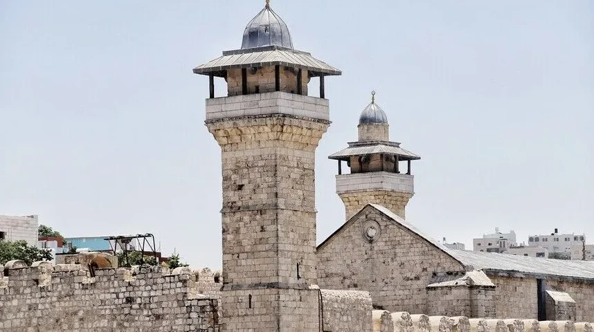 Dva kamena minareta džamije pod vedrim nebom.
