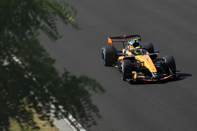 Formula 1 bolid McLaren narandžaste boje u pokretu na trkačkoj stazi.