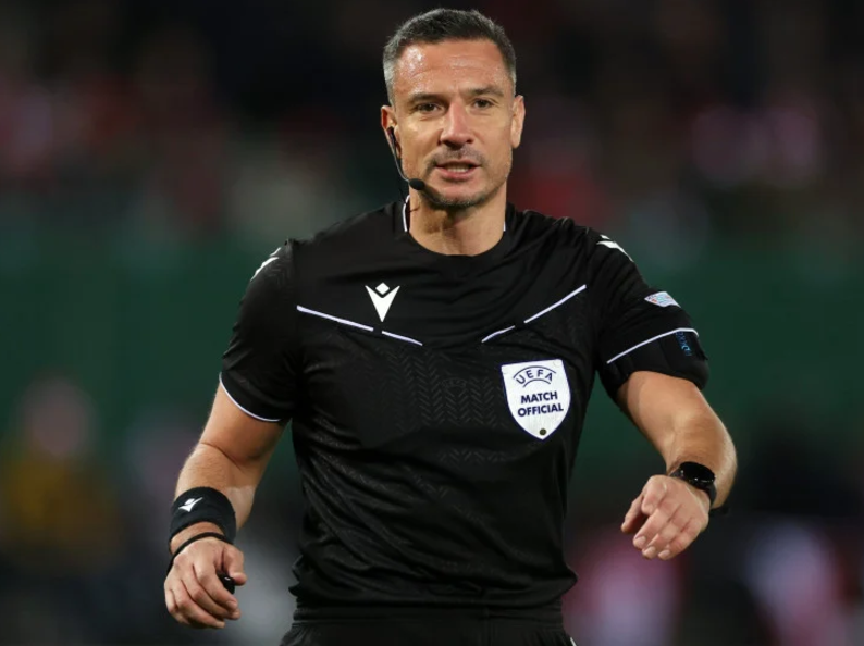 Fudbalski sudija u crnom dresu sa oznakom UEFA Match Official