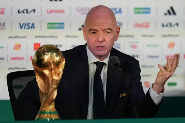 Đani Infantino, predsjednik FIFA-e, sjedi pored trofeja Svjetskog kupa na konferenciji za novinare.